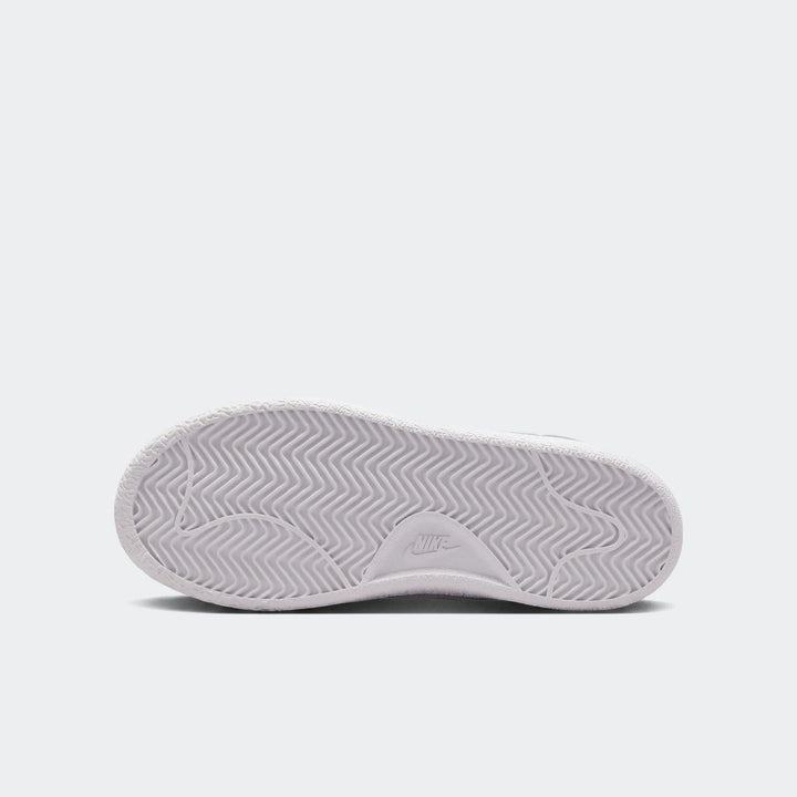 White Nike Tennis Classic Big Kids' shoe sole, showing the textured outsole and wavy traction pattern in a top-down view.