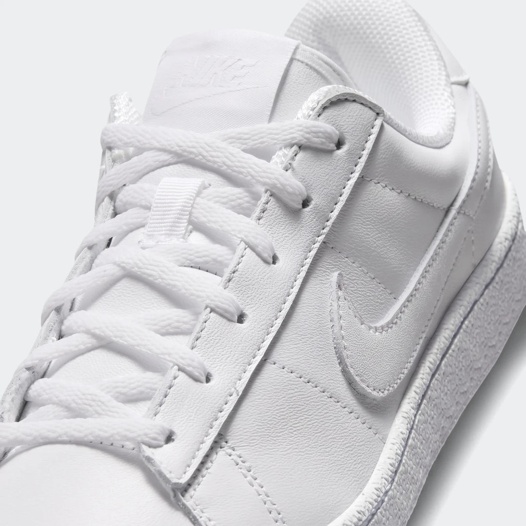 Close-up view of white leather Nike Tennis Classic Big Kids' Shoes with visible laces and swoosh detail.