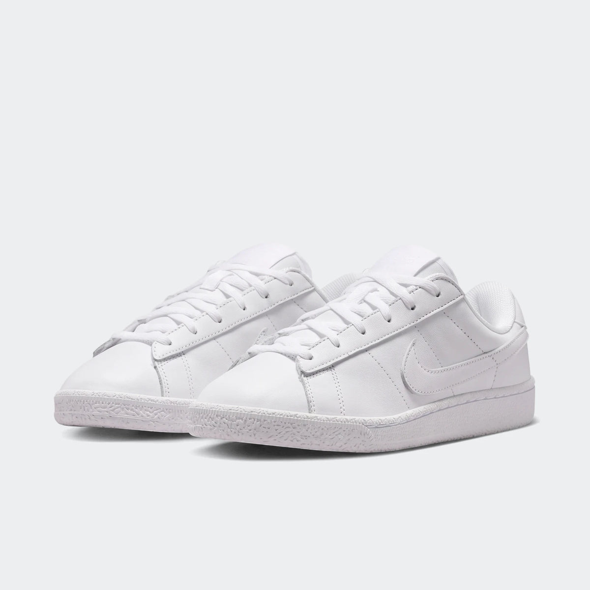 Pair of white Nike Tennis Classic Big Kids' sneakers with laces, made from a smooth leather-like material.