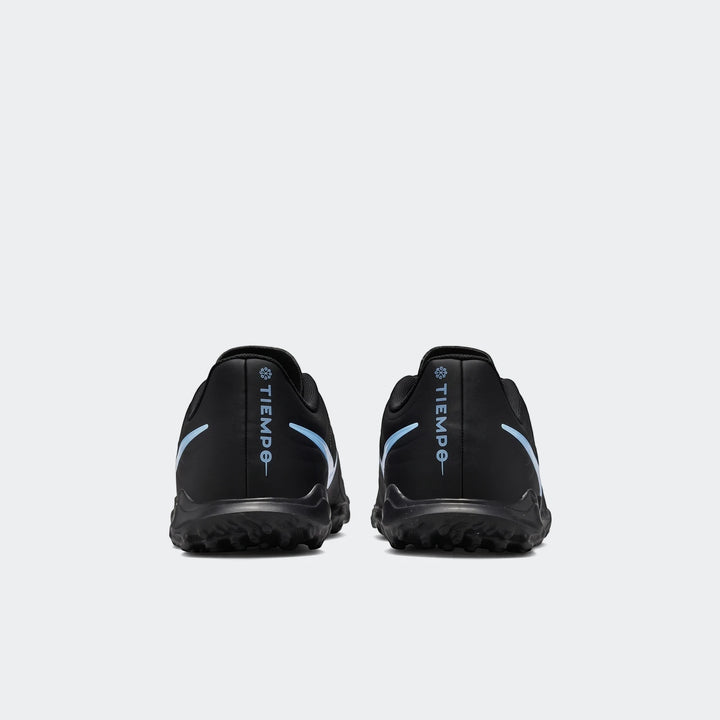 Pair of black Nike Tiempo Maestro Club TF soccer boots, shown from the rear, featuring light blue branding and textured