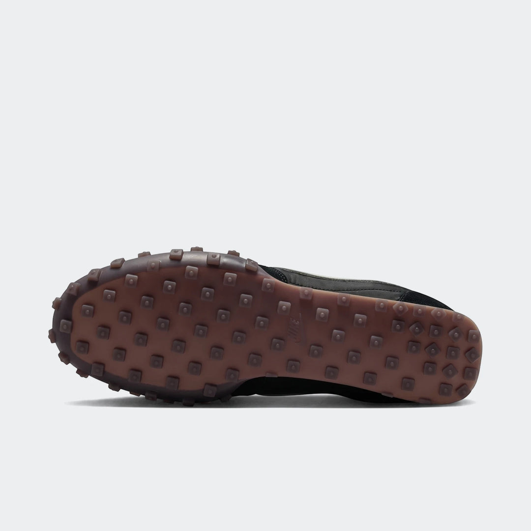 Nike Waffle Racer men's shoe in black with grey accents, viewed from the bottom to showcase its distinctive brown waffle