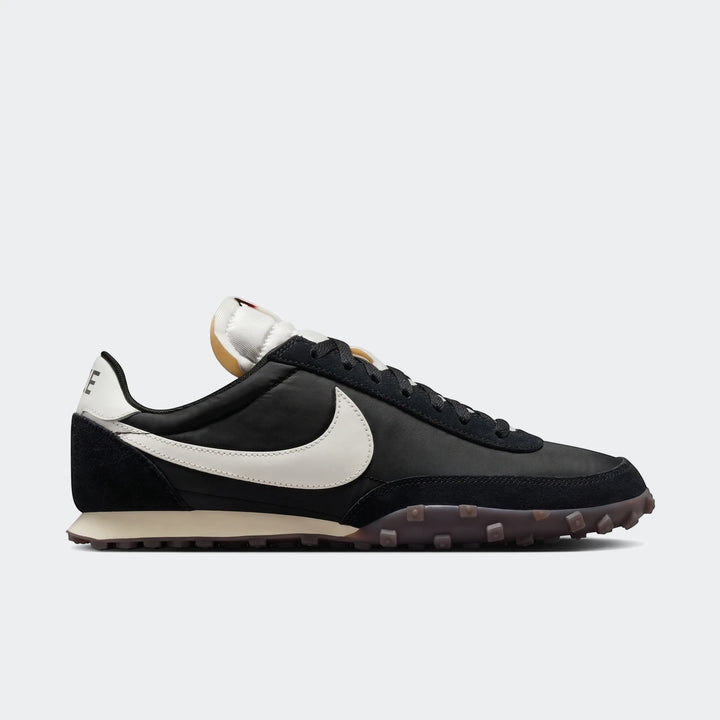 Nike Waffle Racer black men's shoe with white swoosh, featuring suede and nylon, in a side profile view.