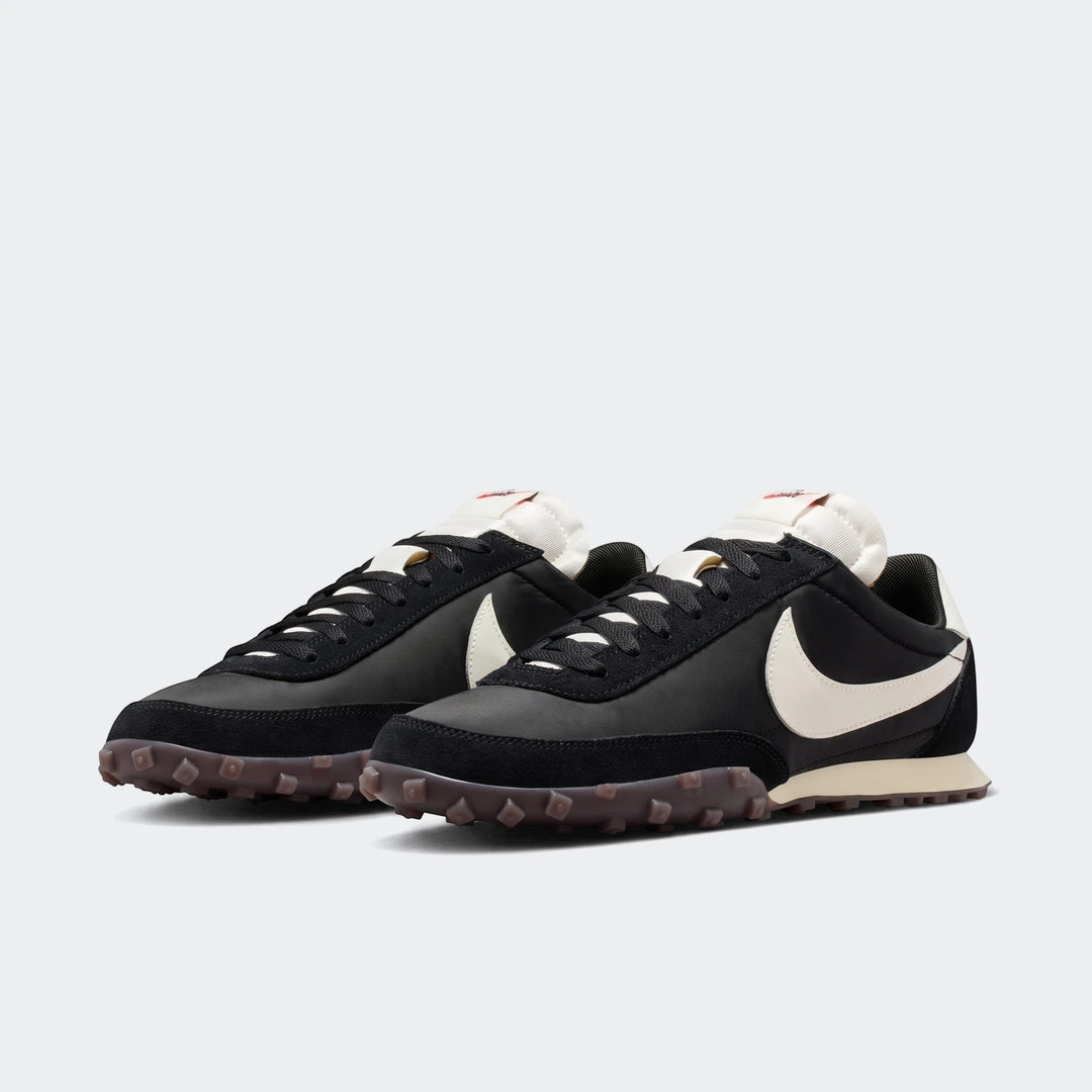 Pair of Nike Waffle Racer men's shoes in black and off-white, shown from a side-front angle.