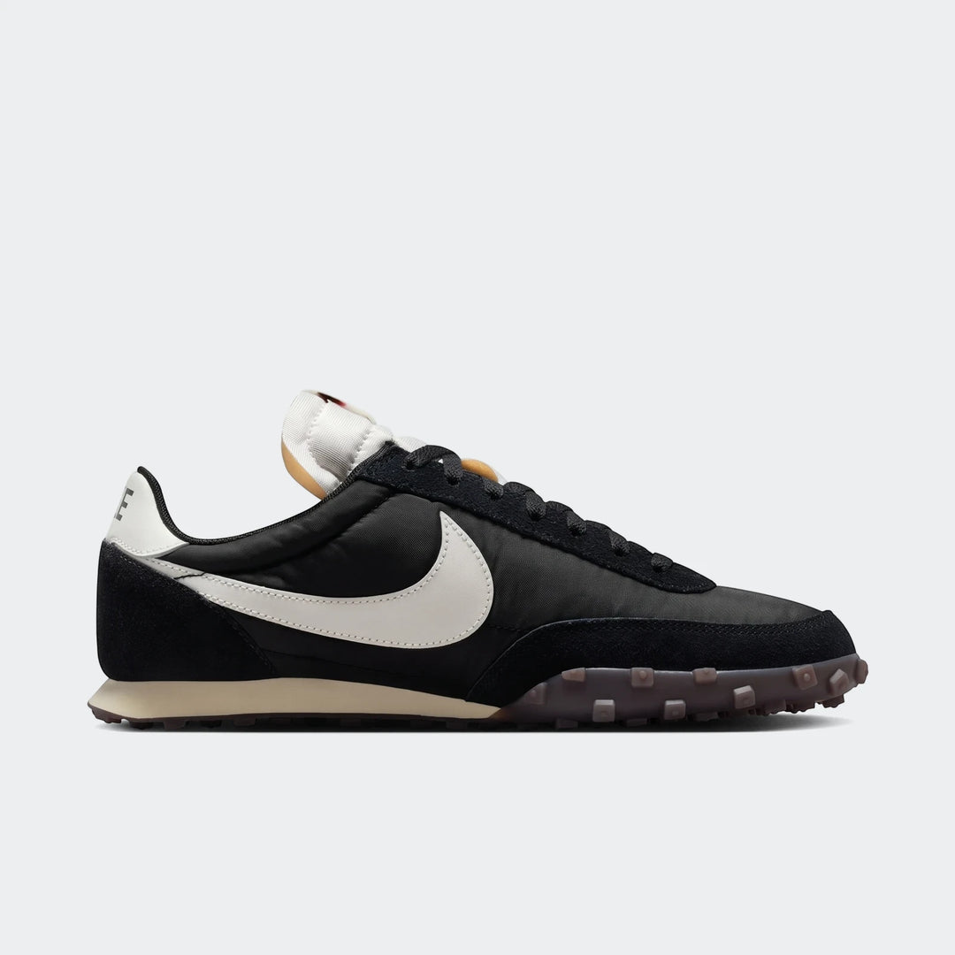 Black Nike Waffle Racer men's shoe with a white swoosh and a distinctive waffle sole, viewed from the side.