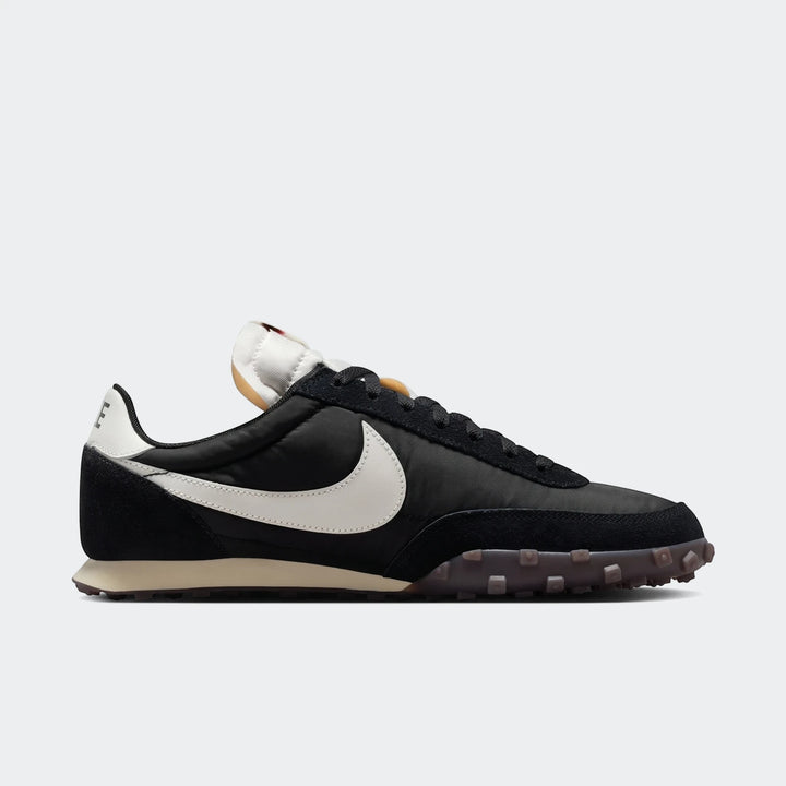 Black Nike Waffle Racer men's shoe with a white swoosh and a distinctive waffle sole, viewed from the side.