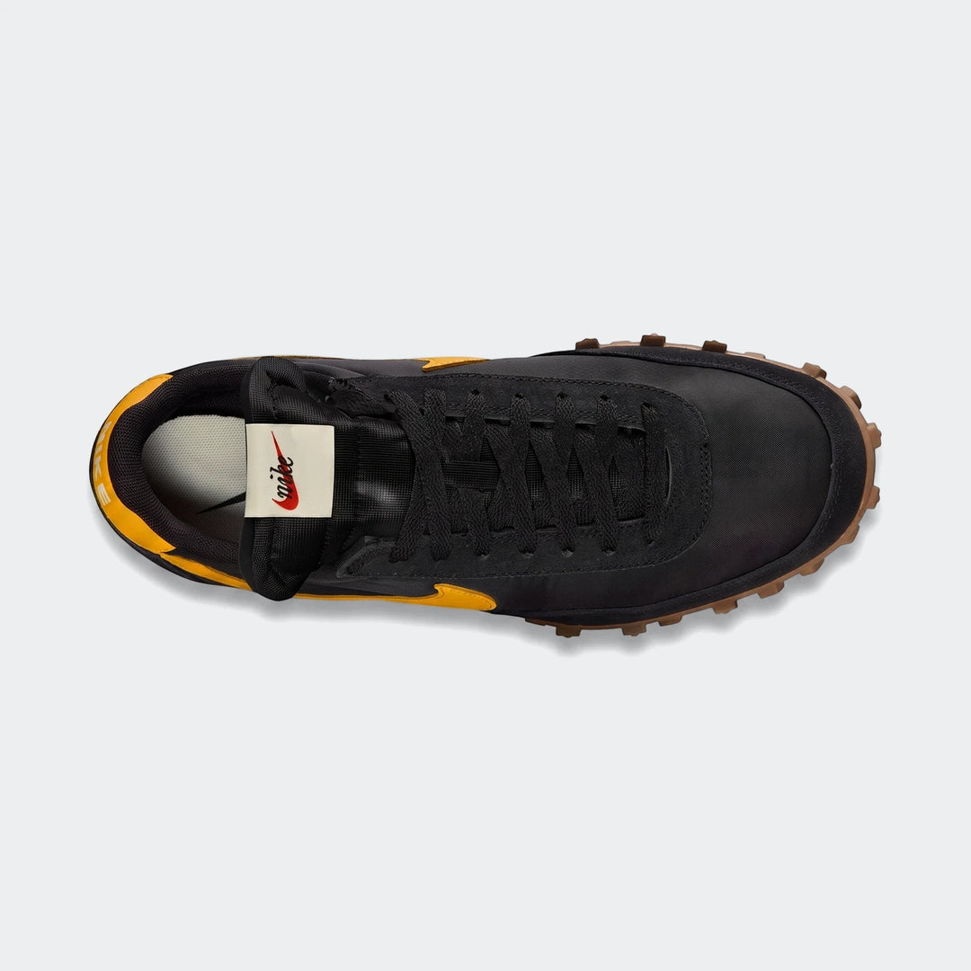Top-down view of a Nike Waffle Racer men's shoe. It features a black upper with yellow accents, black laces, and a textured