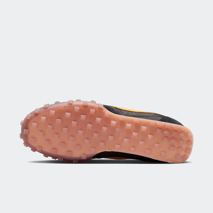 Nike Waffle Racer men's shoe, featuring a black upper with yellow accents and a translucent peach waffle outsole, seen from