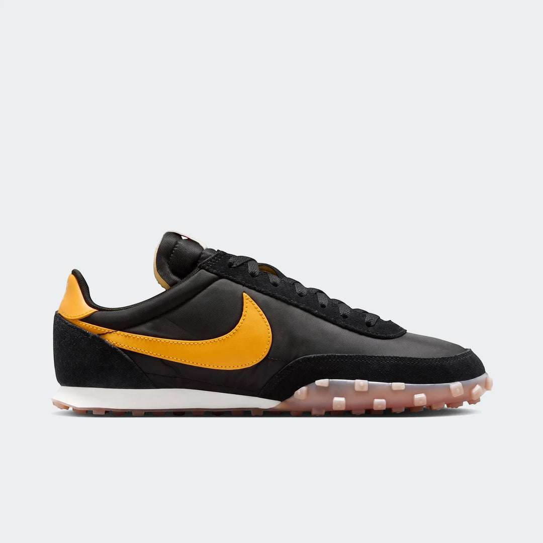 Nike Waffle Racer Men's Shoes in black with a yellow Nike swoosh, visible in a profile view, featuring a white midsole and a