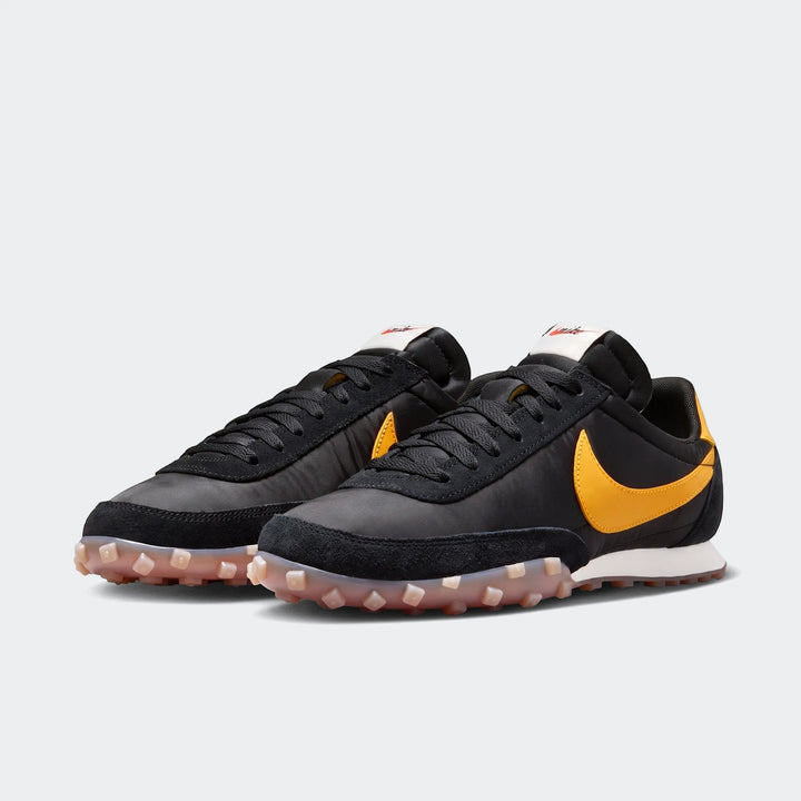 Pair of black and yellow Nike Waffle Racer men's shoes, visible from a side angle, showcasing the iconic yellow Swoosh.