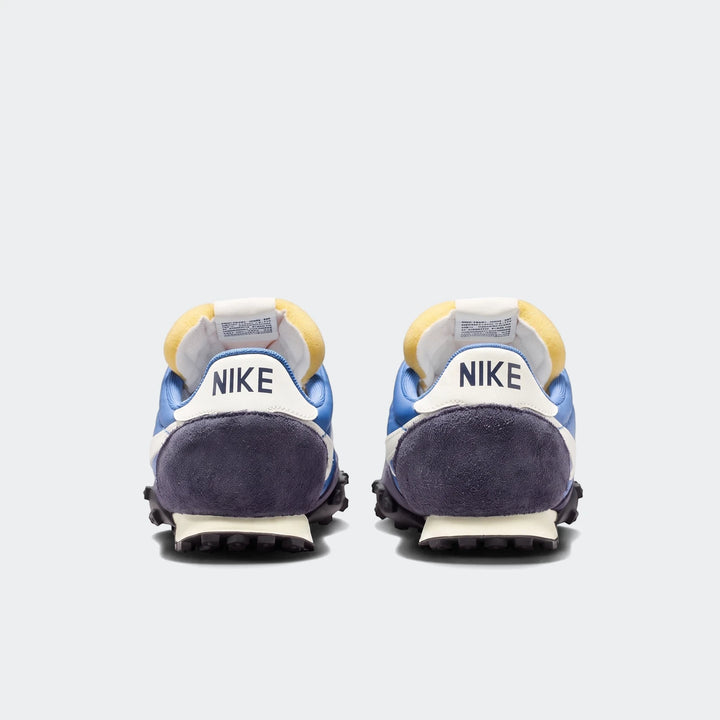 Rear view of two Nike Waffle Racer Men's Shoes in blue and dark blue, showcasing the iconic 'NIKE' logo and studded outsole.
