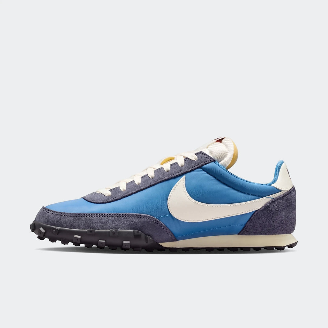 Nike Waffle Racer Men's Shoes, in blue and dark grey, displayed from a side view with white laces and a cream swoosh.