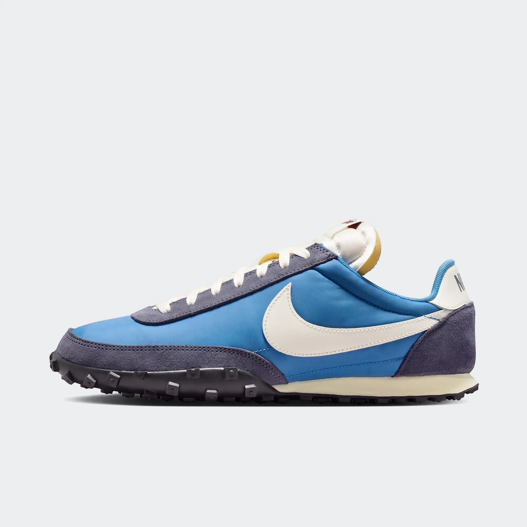 Blue Nike Waffle Racer men's shoes with dark blue suede and off-white swoosh, displayed in a side view.