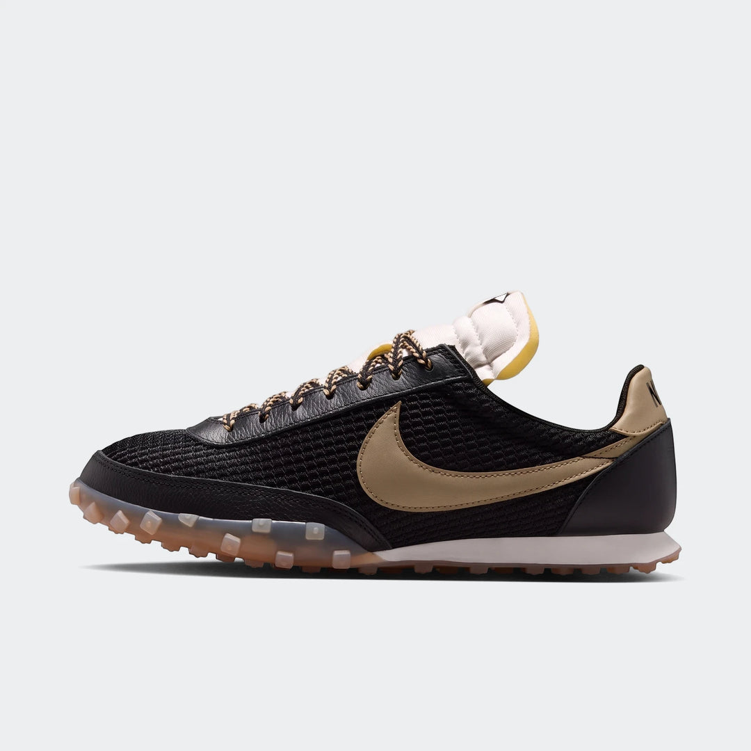 Nike Waffle Racer Se men's shoes in black with gold swoosh and translucent lugged outsole, viewed from the side.
