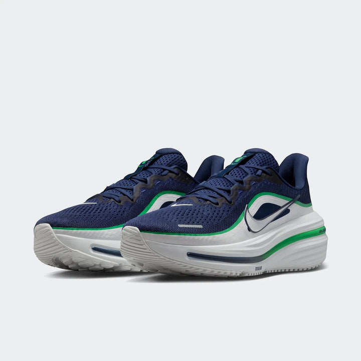 A pair of Nike Winflo 12 men's road running shoes in navy blue, white, and green, displayed at an angle.
