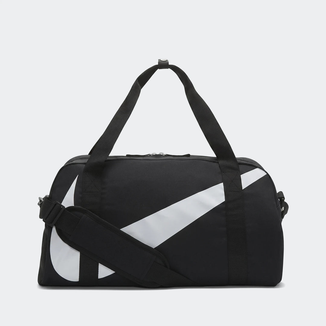 Black Nike Y Nk Gym Club Sp23 duffel bag with a large white swoosh logo, two carry handles, and a shoulder strap, shown from