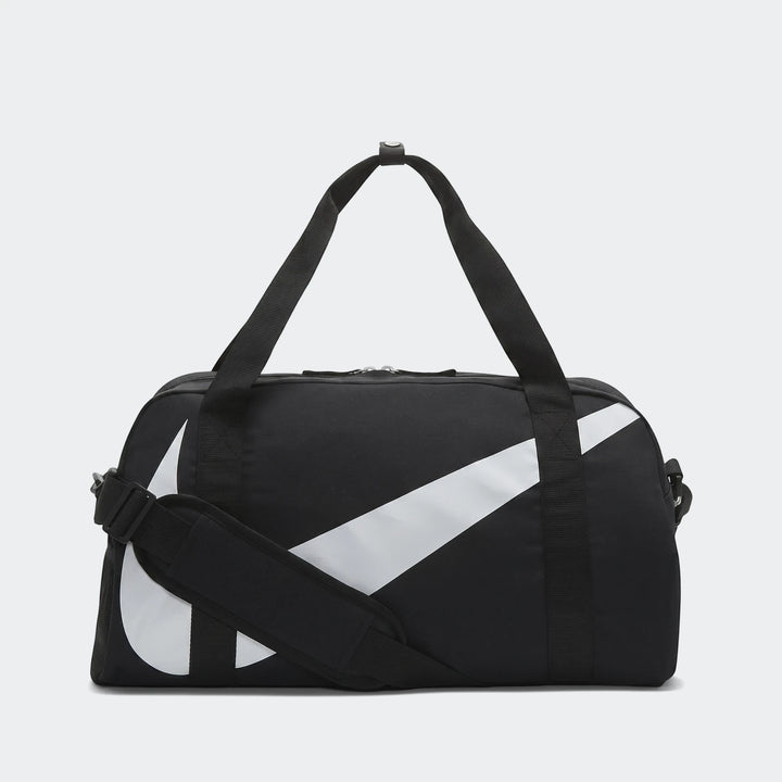 Black Nike Y Nk Gym Club Sp23 duffel bag with a large white swoosh logo, two carry handles, and a shoulder strap, shown from