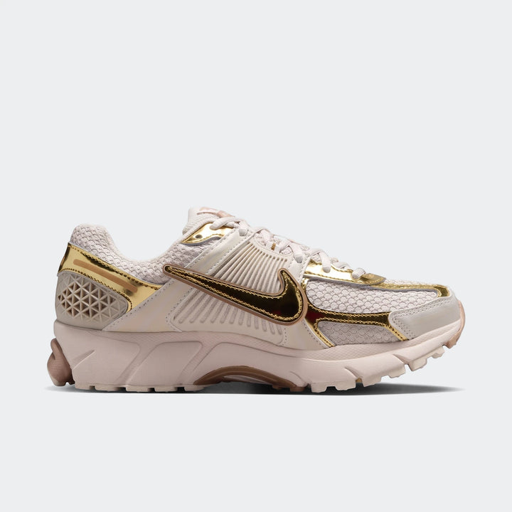 Nike Zoom Vomero 5 women's shoes in off-white mesh with gold metallic overlays and a dark bronze swoosh.