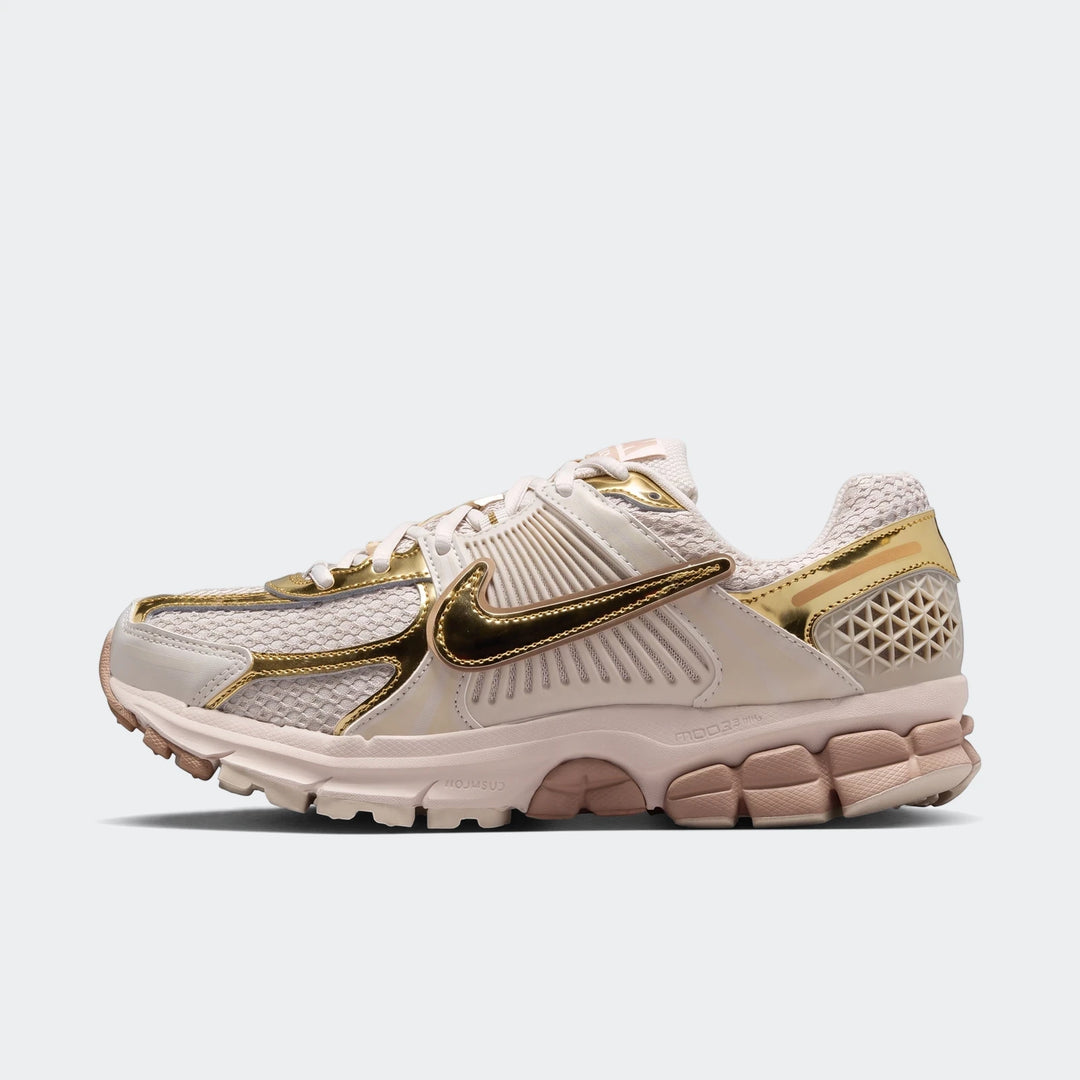 Nike Zoom Vomero 5 Women's Shoes in off-white and metallic gold with a mesh upper, presented in a side profile view.