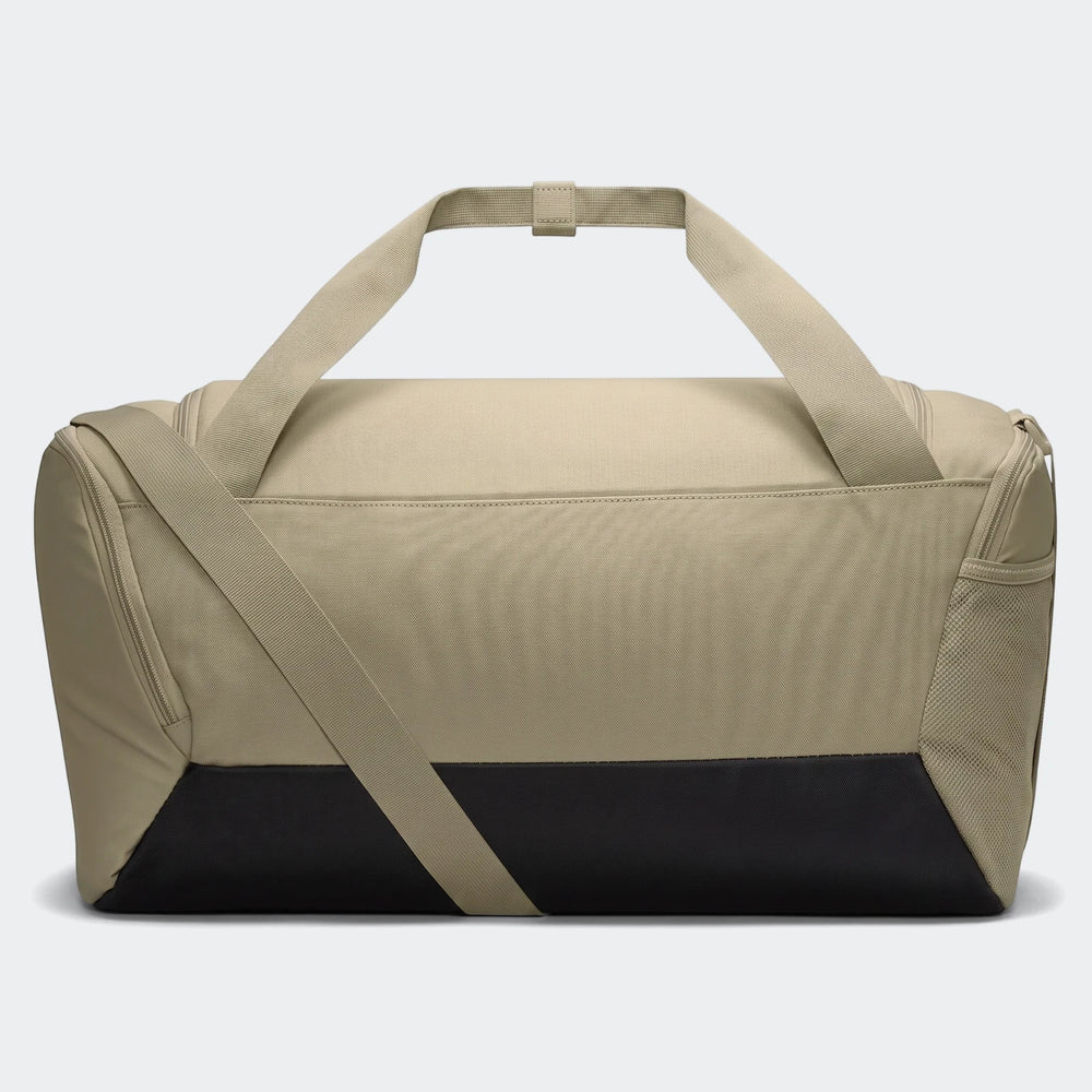 Nk Brsla S Duff 9.5 tan and black duffel bag, featuring top handles and an adjustable shoulder strap, displayed from a side