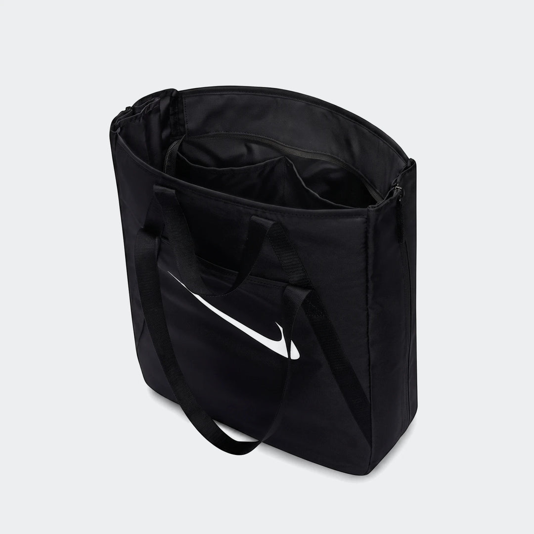 Black Nike gym tote bag, open from a slightly elevated view, showcasing its spacious interior and white swoosh logo.