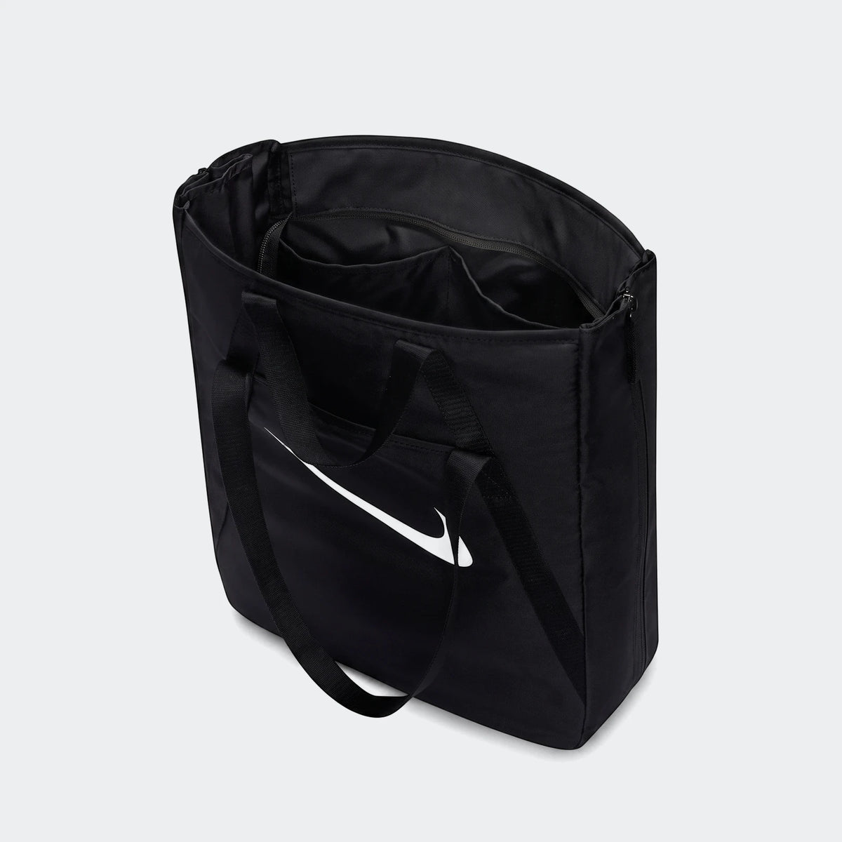 Black Nike gym tote bag, open from a slightly elevated view, showcasing its spacious interior and white swoosh logo.