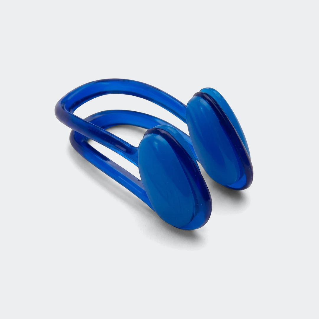 Blue plastic nose clip, a swim accessory, shown angled on a white background, highlighting its design and smooth finish.
