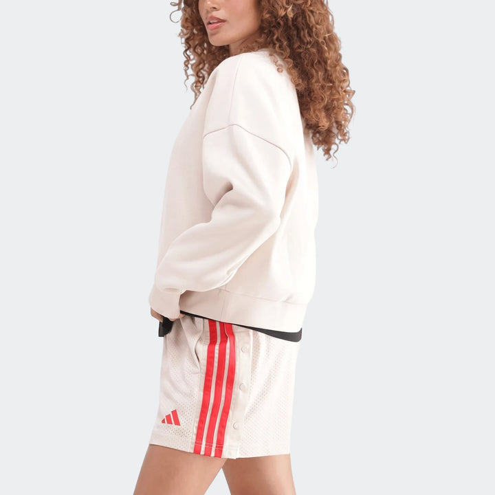 A woman models an off-white Slim Fleece Crew Sweatshirt, paired with white mesh shorts featuring red stripes and an Adidas