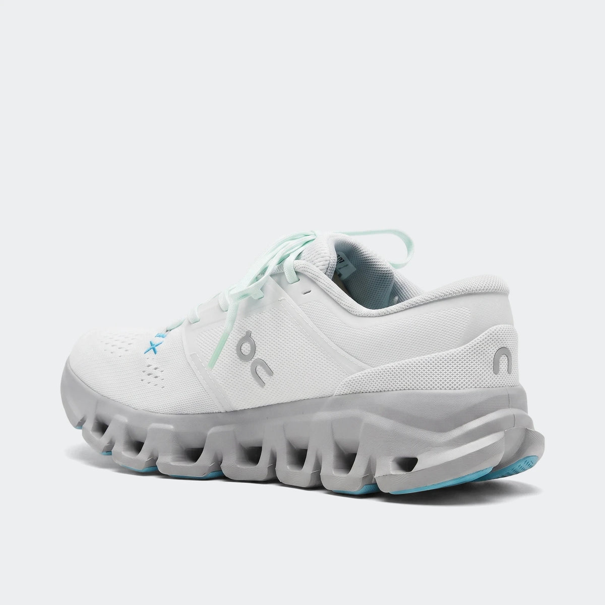 White and gray On Running Cloud X 5 sneakers with blue accents, shown from a rear-side view on a flat surface.
