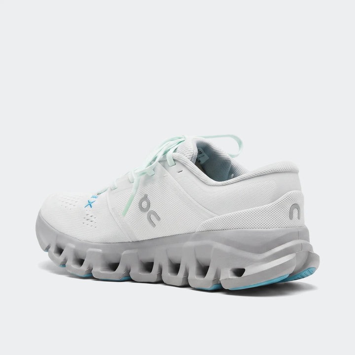 White and gray On Running Cloud X 5 sneakers with blue accents, shown from a rear-side view on a flat surface.