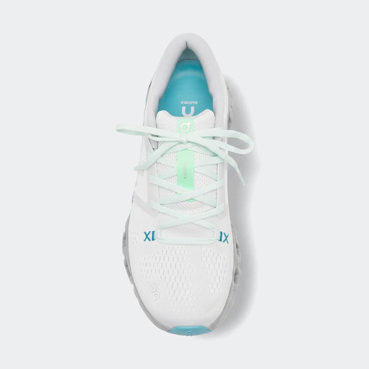 White On Running Cloud X 5 sneakers with mint green laces and light grey soles, photographed from a top-down view.