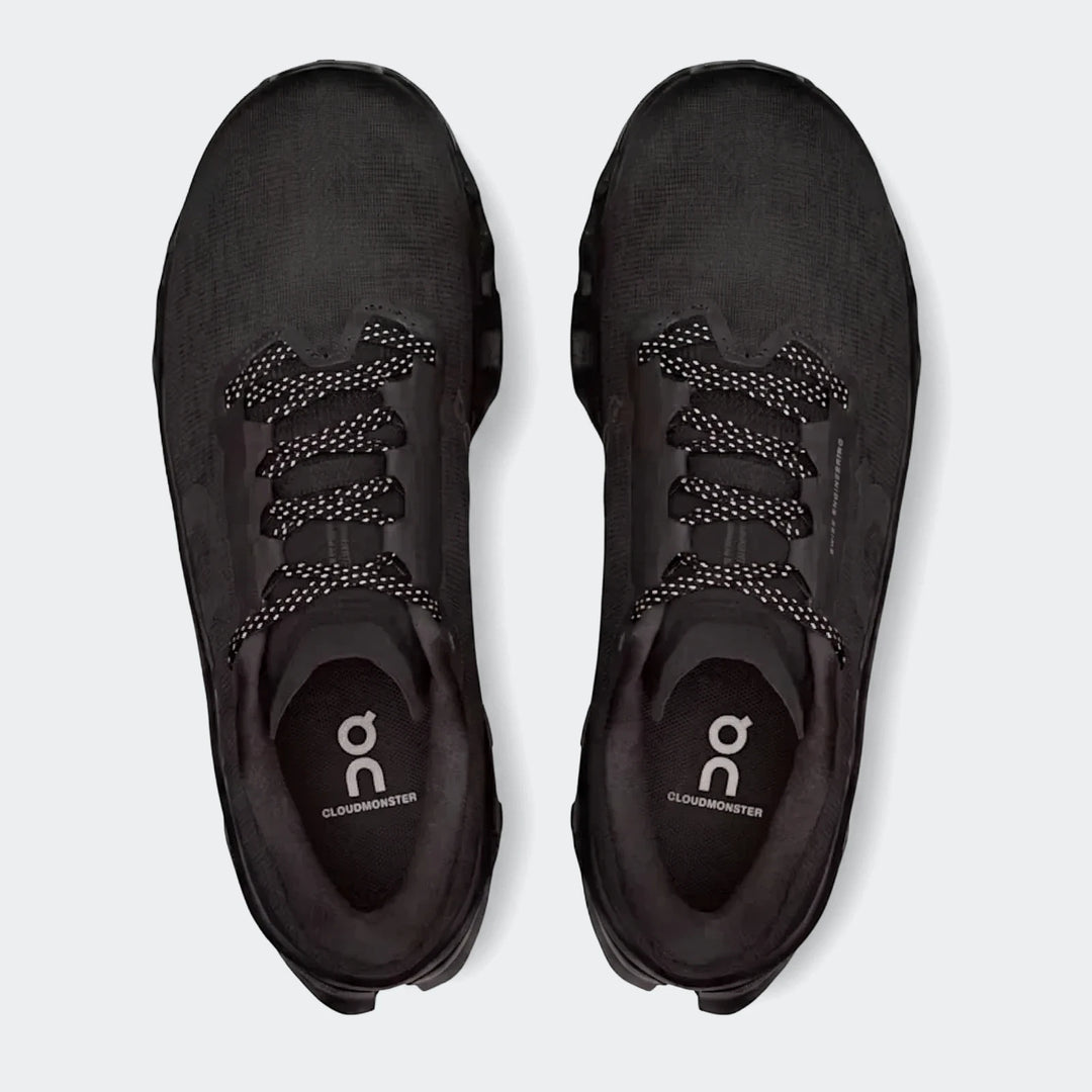 Pair of black On Running Cloudmonster 3 men's running sneakers with white speckled laces, viewed from above.