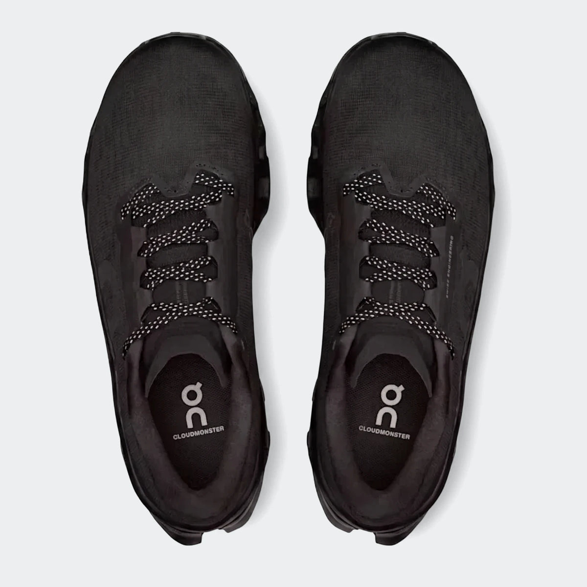 Pair of black On Running Cloudmonster 3 men's running sneakers with white speckled laces, viewed from above.