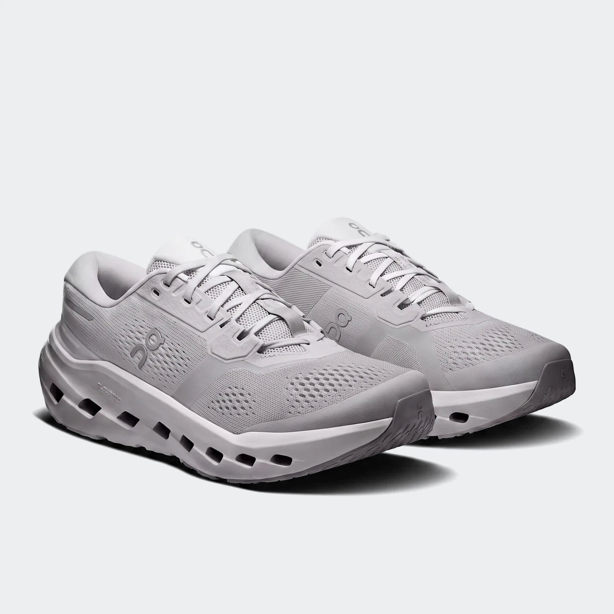 A pair of light grey On Running Cloudrunner 3 Glacier sneakers, showcasing their design and sole technology from an angled