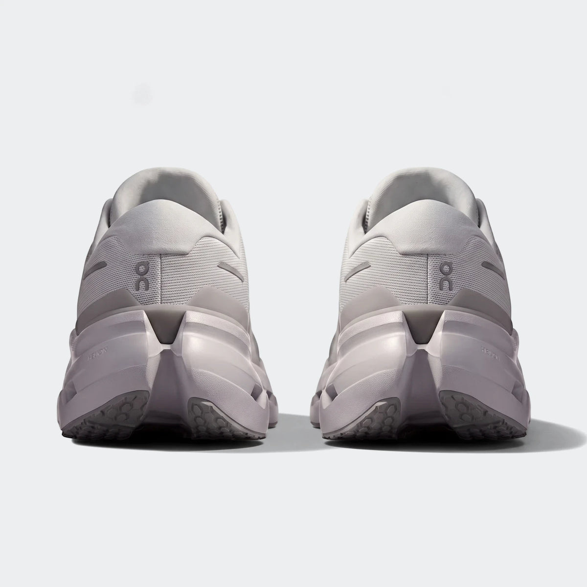 Rear view of two On Running Cloudrunner 3 Glacier sneakers, showcasing their light grey mesh upper and supportive sole.