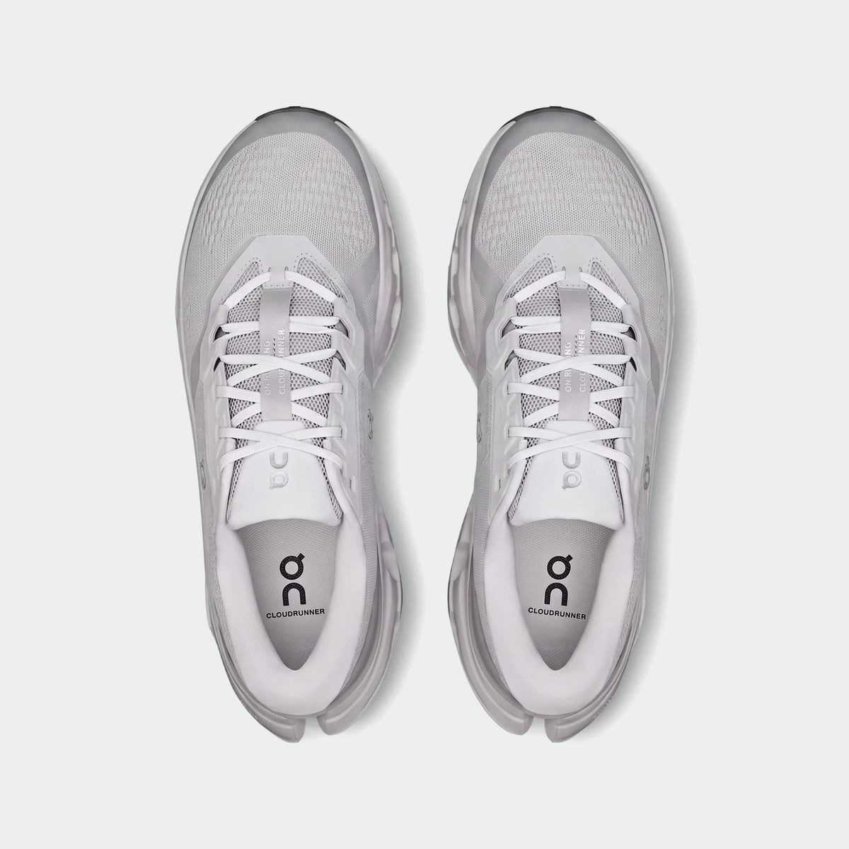 Top-down view of two On Running Cloudrunner 3 Glacier white and light gray running sneakers with prominent branding.