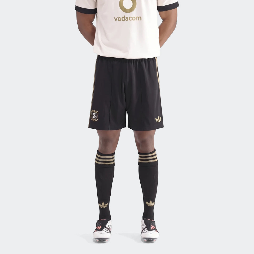 Op A Sho, black and gold soccer shorts and socks with white cleats on a person, front view.