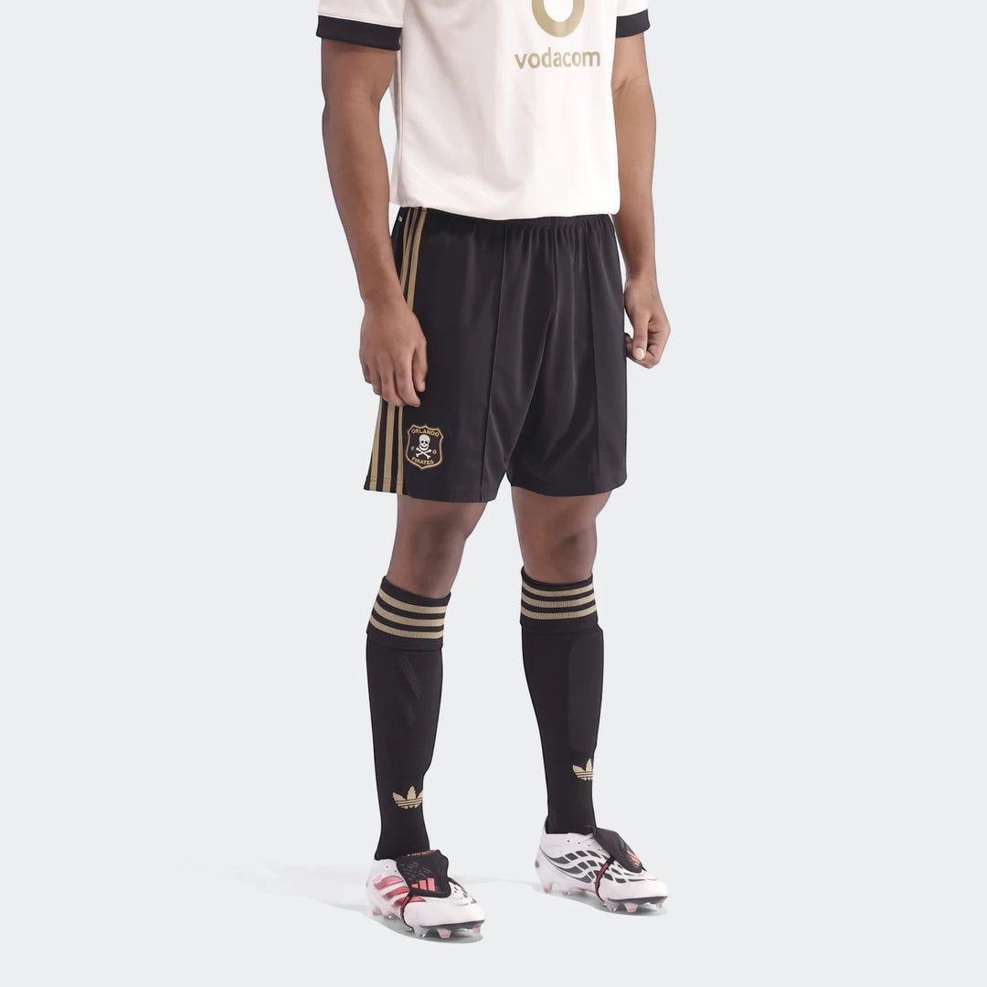 Male model wearing Op A Sho soccer uniform, featuring a white and gold jersey, black and gold shorts, black socks, and white