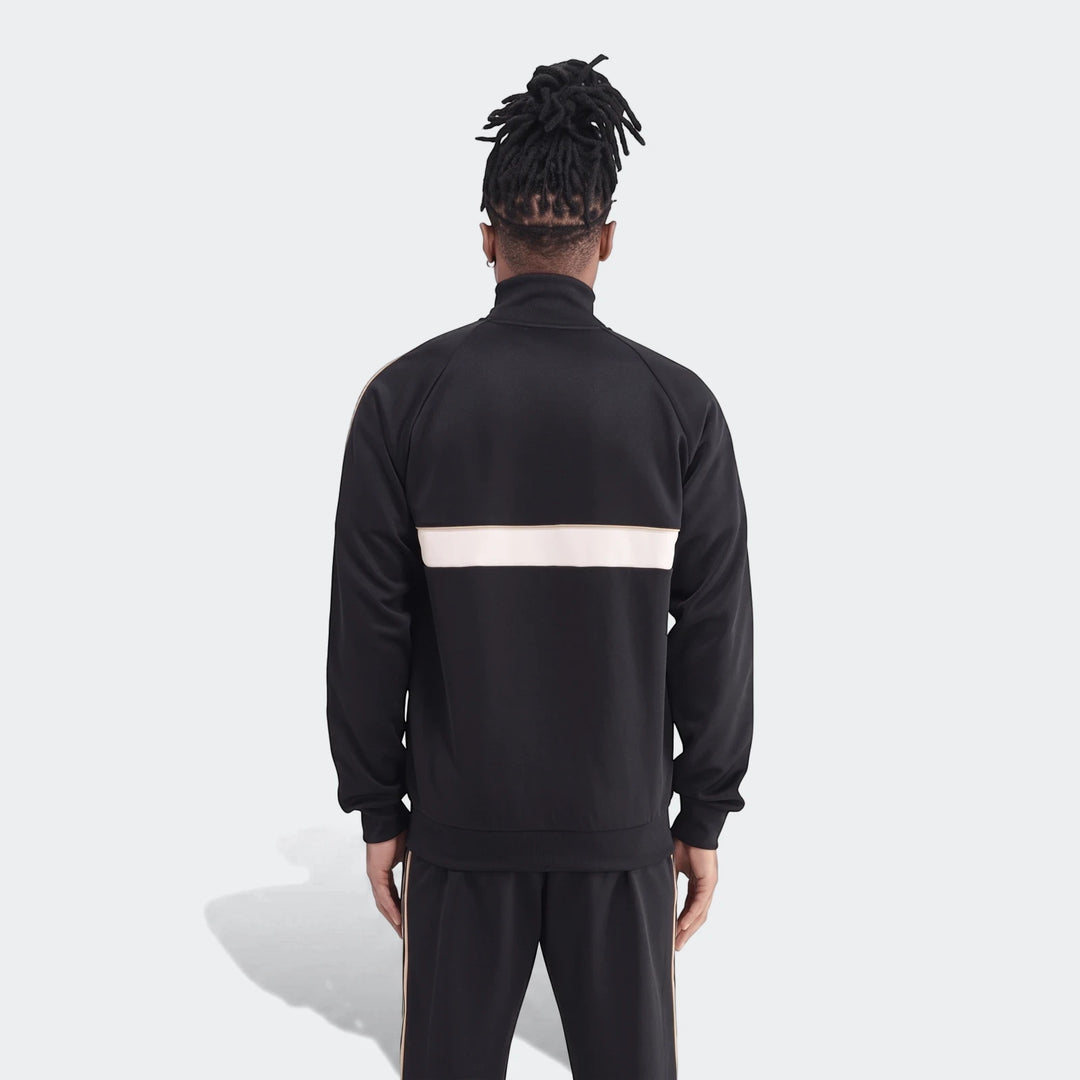 Back view of a male model wearing the black Op Og2 Tt track jacket with white and gold stripes, paired with matching track