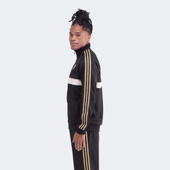 Men's Op Og2 Tt black track jacket and matching pants with gold stripes, shown from a side view.