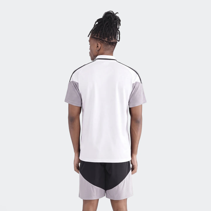 Male model from back wearing white and grey Op Tiro26C Polo shirt and black athletic shorts with grey pattern.
