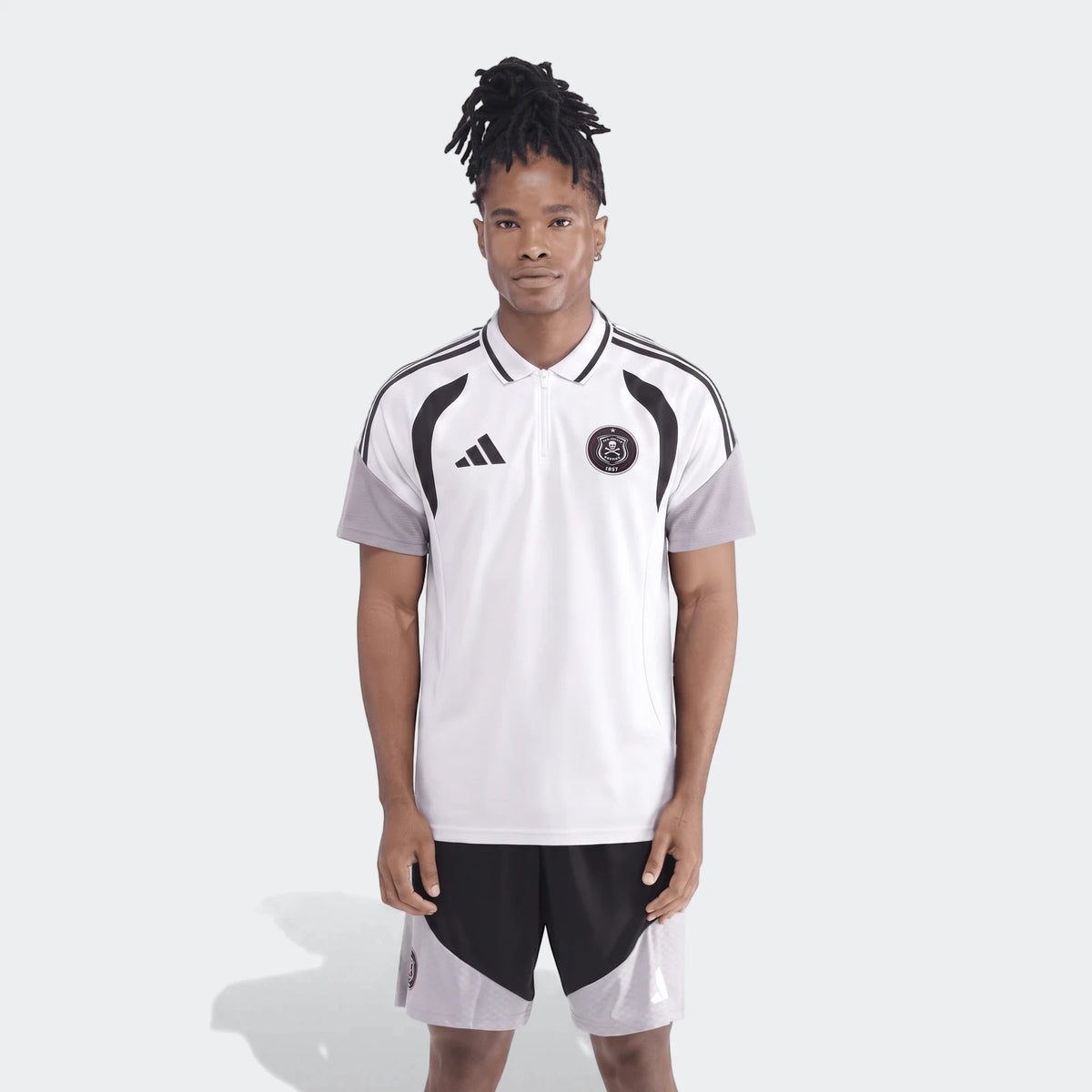Male model wearing an adidas Op Tiro26C Polo in white with black accents and matching black and grey athletic shorts.