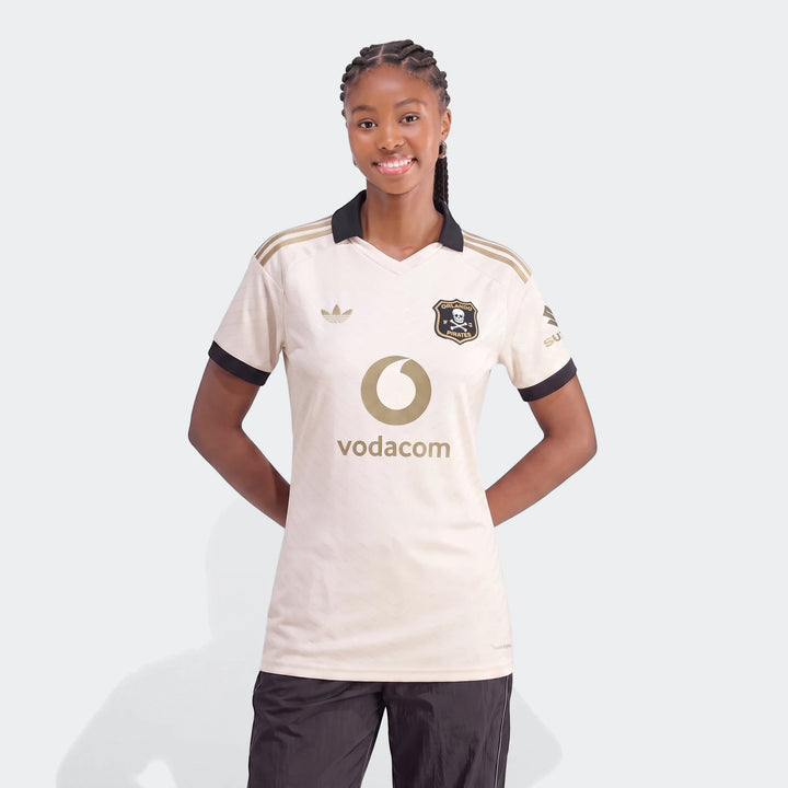 Orlando Pirates 26/27 Away Jersey for women, cream with black and gold details, modeled frontally.