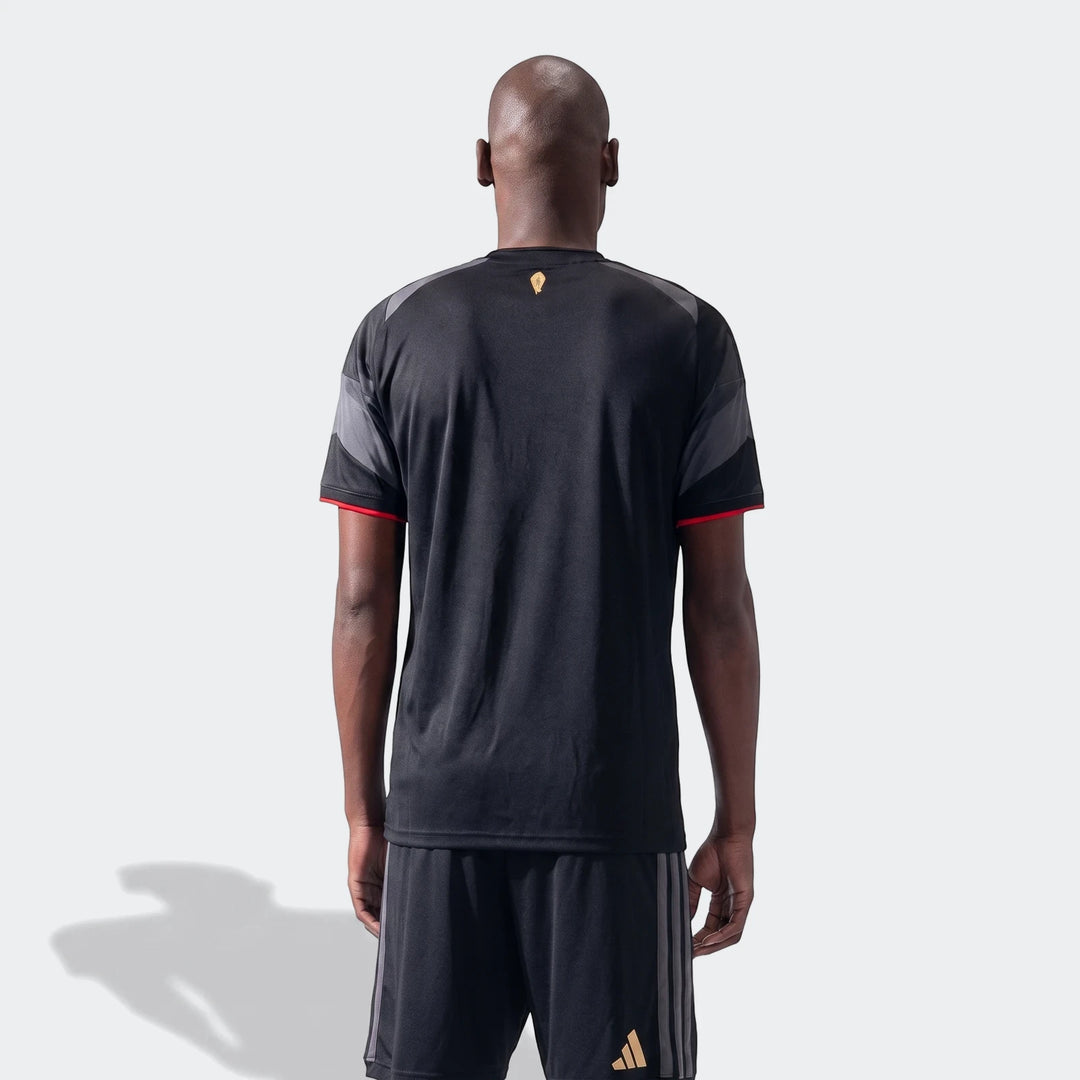 Back view of a male model wearing the black Orlando Pirates 26/27 Home Jersey with grey panels and red trim.