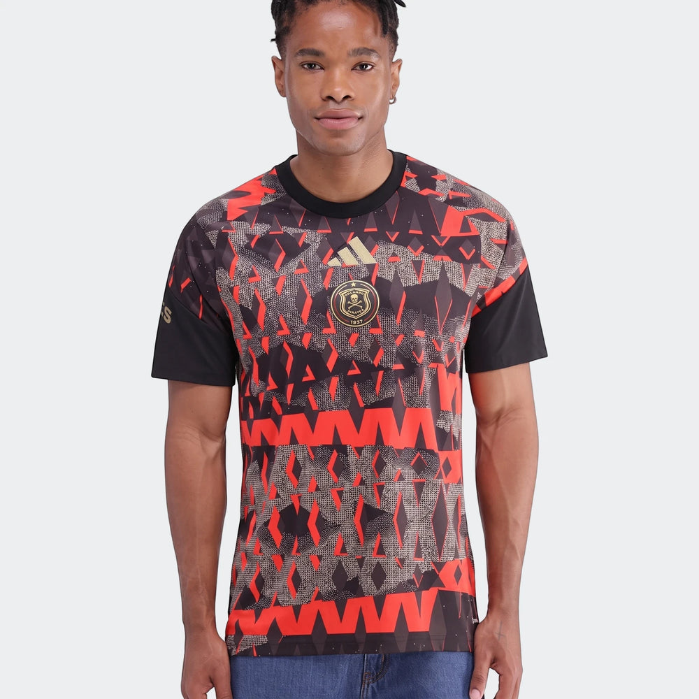 Man wearing an Orlando Pirates 26/27 Pre Match Jersey, featuring a distinctive black and red geometric pattern and gold