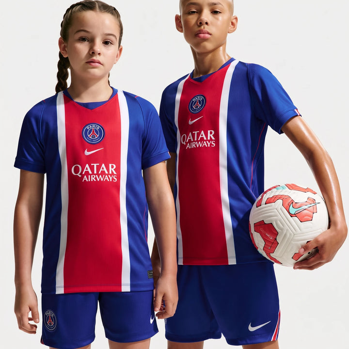 Two kids wearing the Paris Saint-Germain 2026/27 Stadium Home Big Kids' Nike Dri-Fit Soccer Replica Jersey in blue, red, and