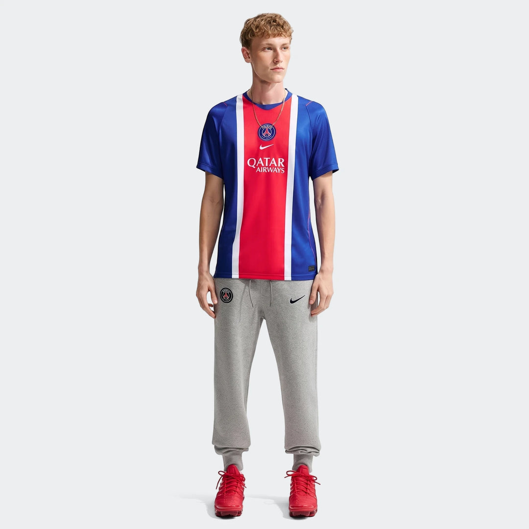 Man wearing Paris Saint-Germain 2026/27 Stadium Home Men's Nike Dri-Fit Soccer Replica Jersey in blue, red, and white with
