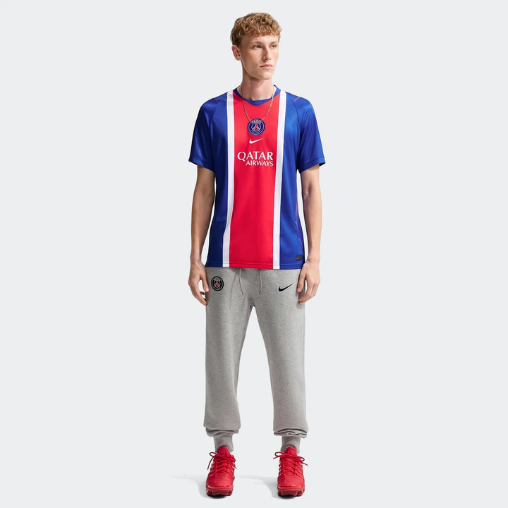 Man wearing Paris Saint-Germain 2026/27 Stadium Home Men's Nike Dri-Fit Soccer Replica Jersey in blue, red, and white with