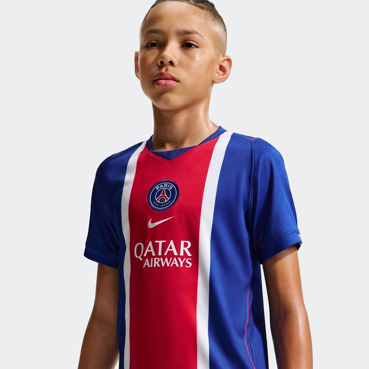 Front view of a young boy wearing the blue, red, and white Paris Saint-Germain 2026/27 Stadium Home Big Kids' Nike Dri-Fit