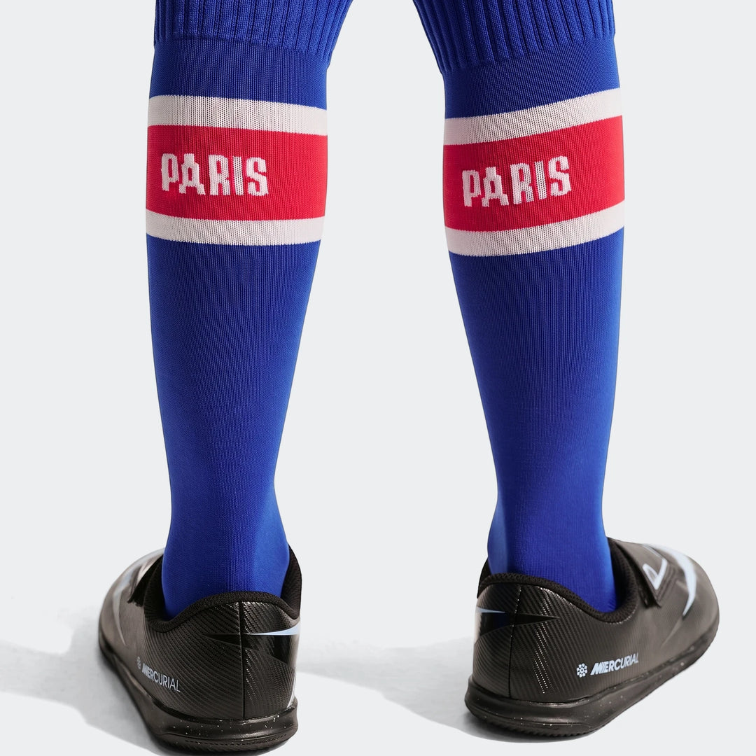 Little kids' Paris Saint-Germain Nike soccer socks in blue with red and white 'PARIS' branding, paired with black Mercurial