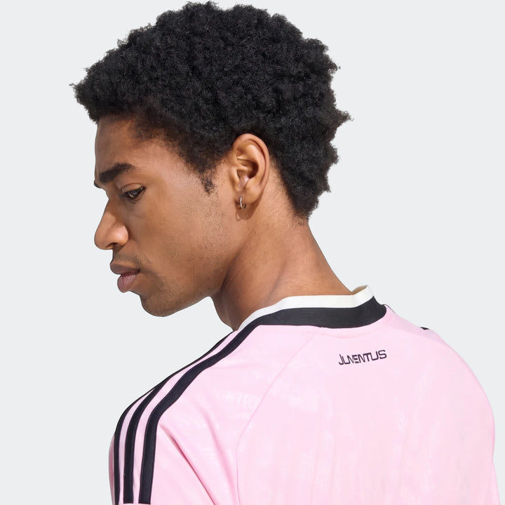 Male model wearing a pink Adidas Juventus 26/27 Away Jersey, view from the back and side, showcasing the team branding and
